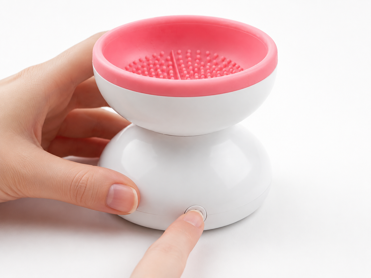 Pressing the button to turn on the Electric Makeup Brush Cleaner